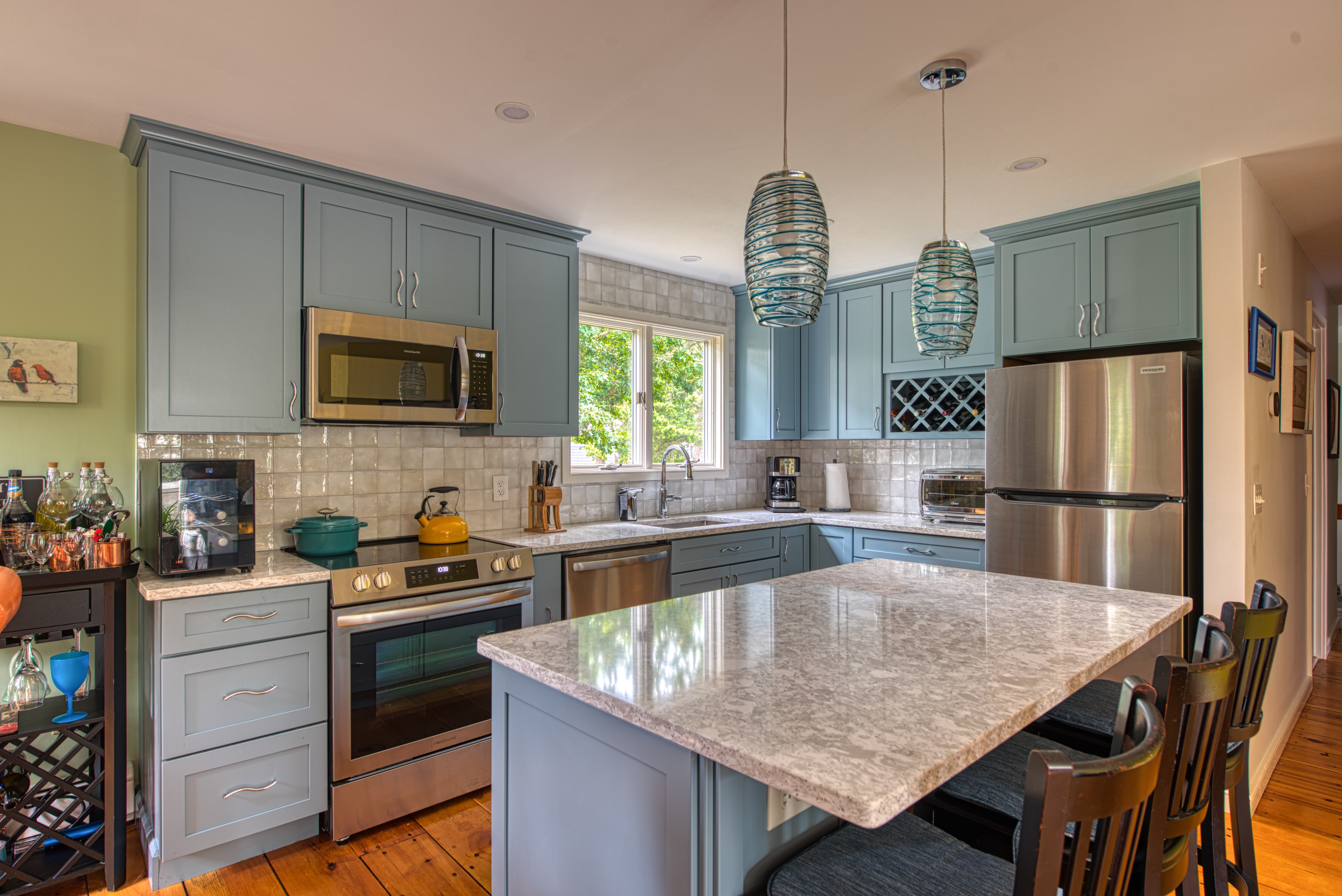 Photo of remodeled kitchen with light blue cabinets and white countertops