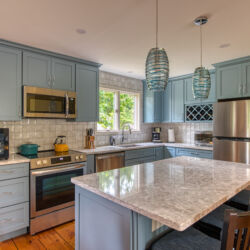 Photo of remodeled kitchen with light blue cabinets and white countertops